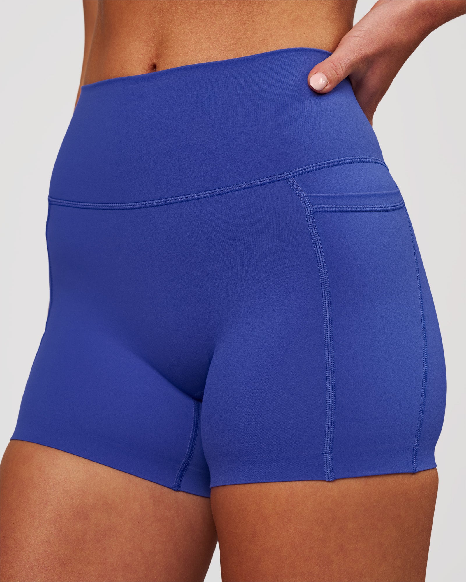Woman wearing Elixir High-Rise 4" Short Pockets - Power Cobalt | Model:Issy | Size:XS