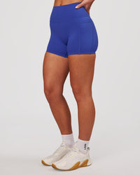 Woman wearing Elixir High-Rise 4" Short Pockets - Power Cobalt | Model:Issy | Size:XS | Thumbnail Index: 5