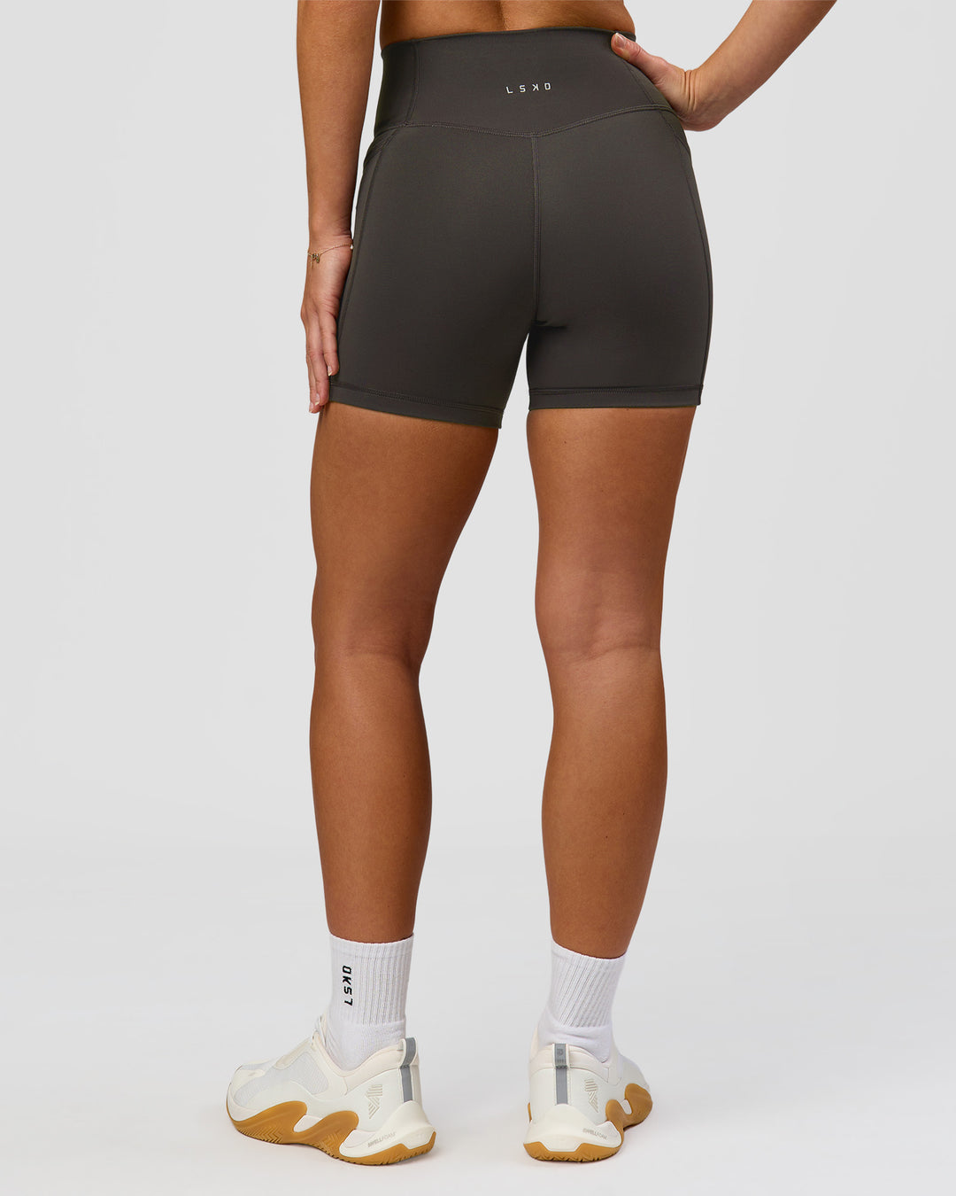 Woman wearing Fusion Ultra High-Rise 4" Short Pockets - Onyx | Model:Issy | Size:XS - view 7