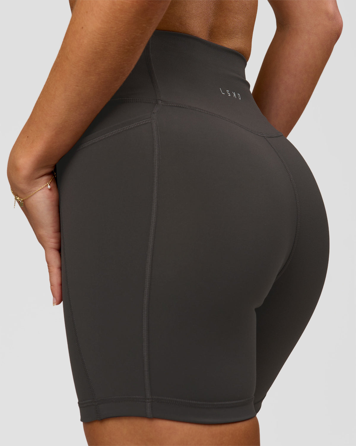 Woman wearing Fusion Ultra High-Rise 6" Short Pockets - Onyx | Model:Issy | Size:XS