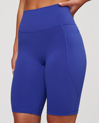 Woman wearing Fusion V Contour Ultra High-Rise 9" Short Pockets - Power Cobalt | Model:Issy | Size:XS | Thumbnail Index: 1