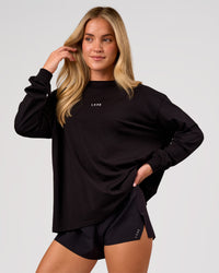 Woman wearing Go-To Long Sleeve FLXCotton Oversized Tee - Black-White | Model:Issy | Size:XS | Thumbnail Index: 0