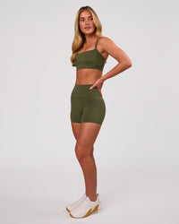 Woman wearing Momentum Corset Sports Bra - Pure Olive | Model:Issy | Size:XS | Thumbnail Index: 4