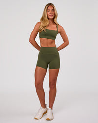 Woman wearing Momentum Corset Sports Bra - Pure Olive | Model:Issy | Size:XS | Thumbnail Index: 5