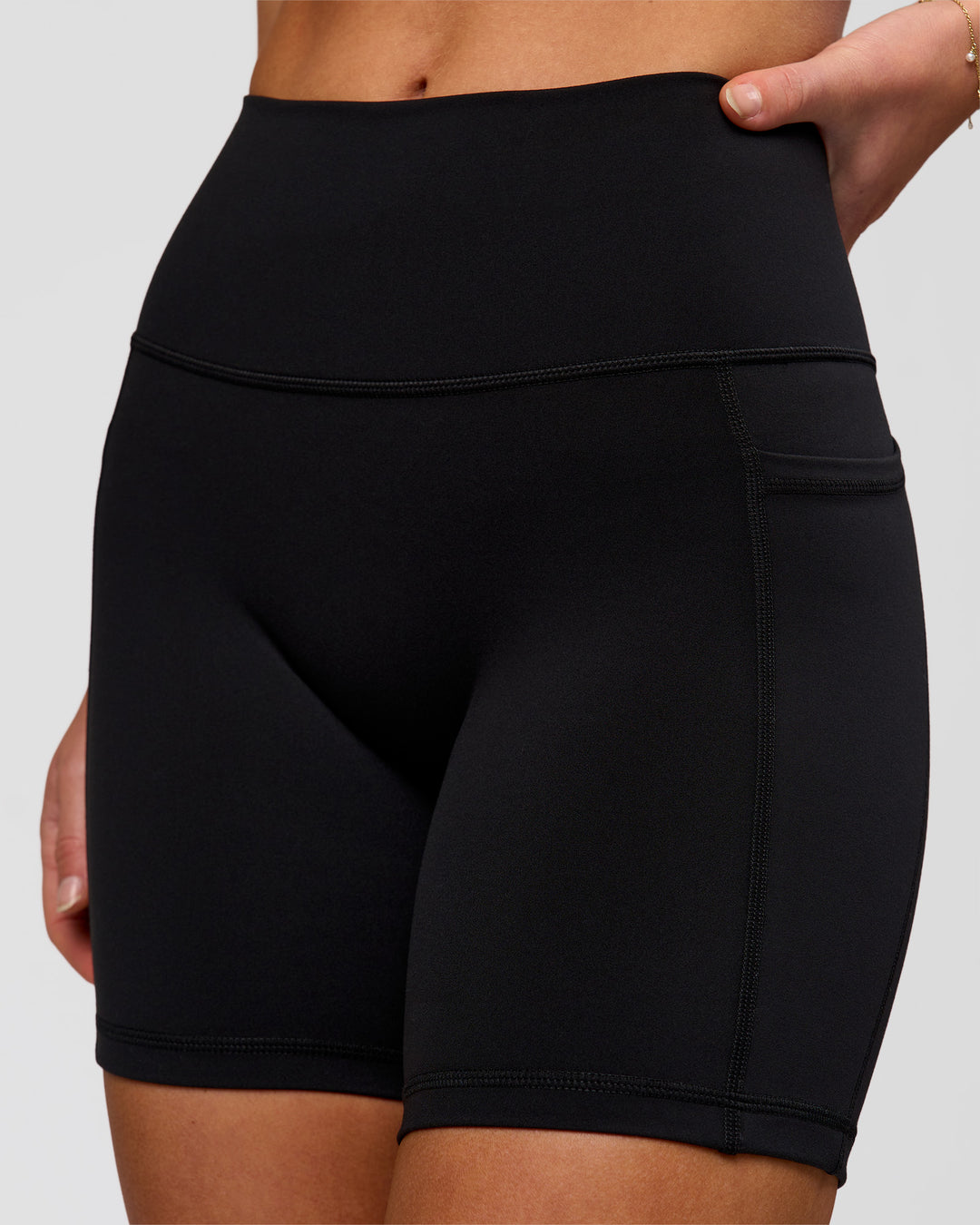Woman wearing O.G. Fusion Ultra High-Rise 6" Short Pockets - Black | Model:Issy | Size:XS - view 2