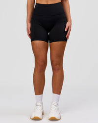 Woman wearing O.G. Fusion Ultra High-Rise 6" Short Pockets - Black | Model:Issy | Size:XS | Thumbnail Index: 4