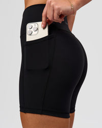Woman wearing O.G. Fusion Ultra High-Rise 6" Short Pockets - Black | Model:Issy | Size:XS | Thumbnail Index: 9