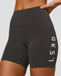 Woman wearing Rep Ultra High-Rise 4" Short Pockets - Onyx-White | Model:Issy | Size:XS | Thumbnail Index: 0
