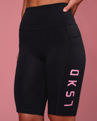 Woman wearing Rep Ultra High-Rise 9" Short Pockets - Black-Pink Rose | Model:Issy | Size:XS | Thumbnail Index: 1