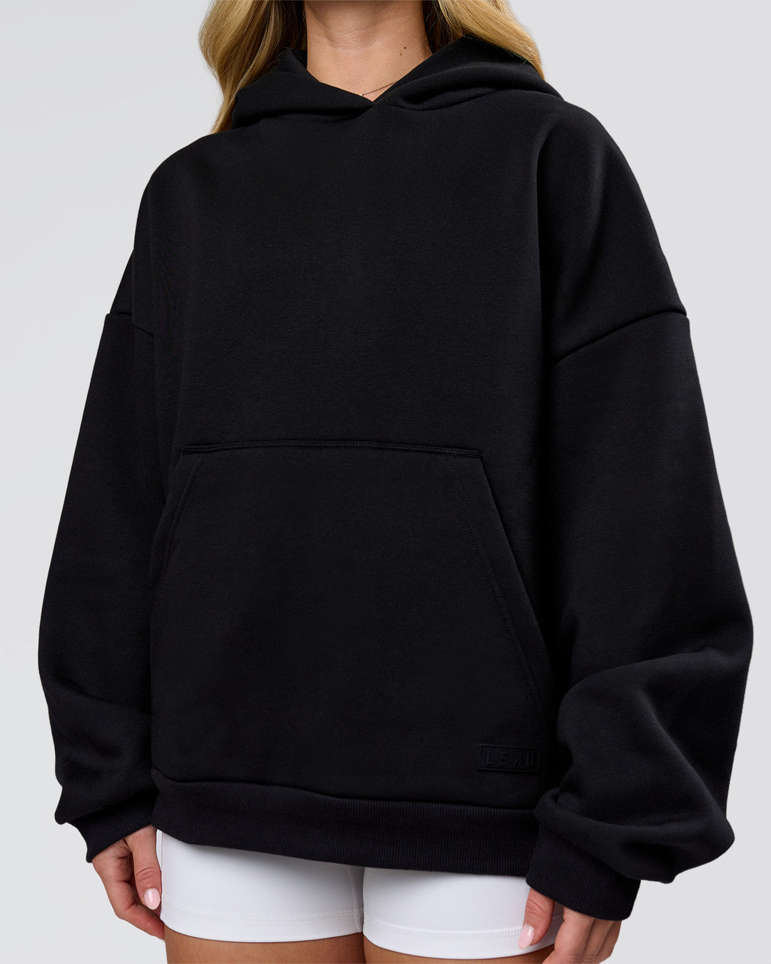 Woman wearing Tonal Legacy Boxy Hoodie - Black-Black | Model:Issy | Size:XS - view 6