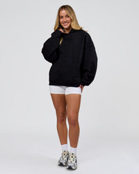 Woman wearing Tonal Legacy Boxy Hoodie - Black-Black | Model:Issy | Size:XS | Thumbnail Index: 14