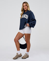 Woman wearing Varsity Boxy Hoodie - Future Navy-White | Model:Issy | Size:XS | Thumbnail Index: 17