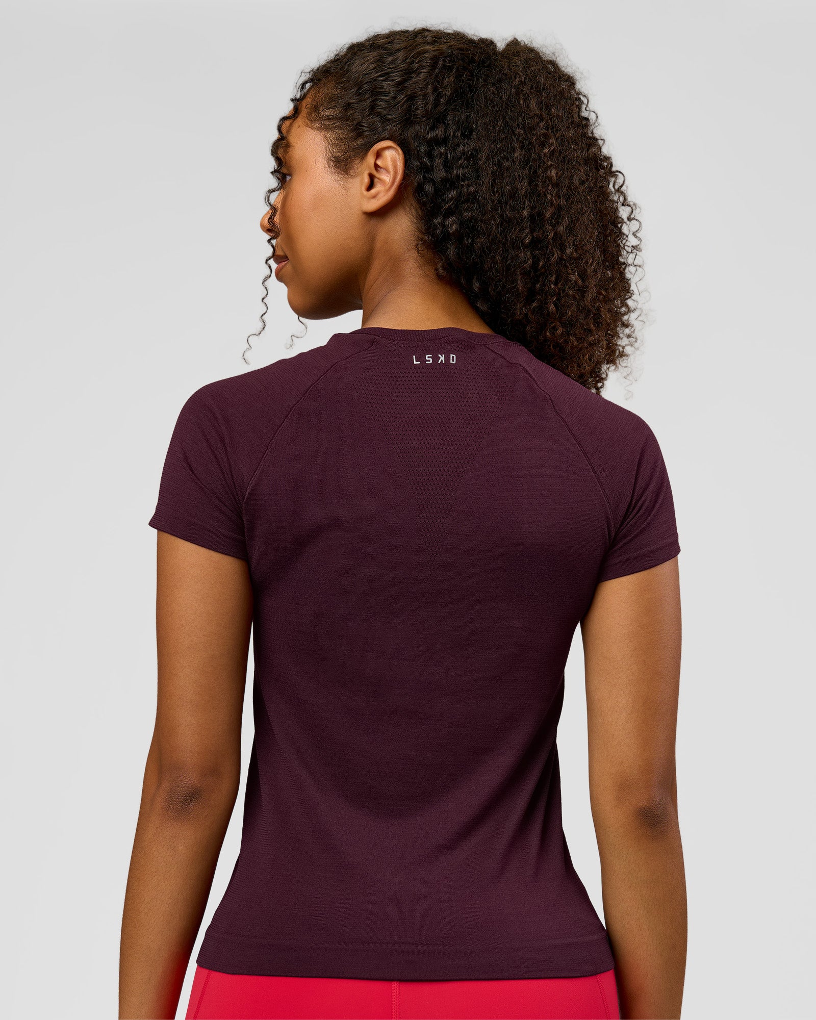 Woman wearing AeroFLX+ Seamless Tee - Cherry Lacquer/Cherry Lacquer | Model:Jordan | Size:XS