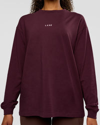 Woman wearing Go-To Long Sleeve FLXCotton Oversized Tee - Cherry Lacquer-White | Model:Jordan | Size:XS | Thumbnail Index: 1
