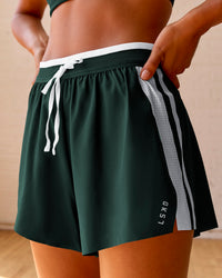 Woman wearing Trackline Accelerate 3" High-Rise Running Short - Midnight Green-White | Model:Meg | Size:XS | Thumbnail Index: 0