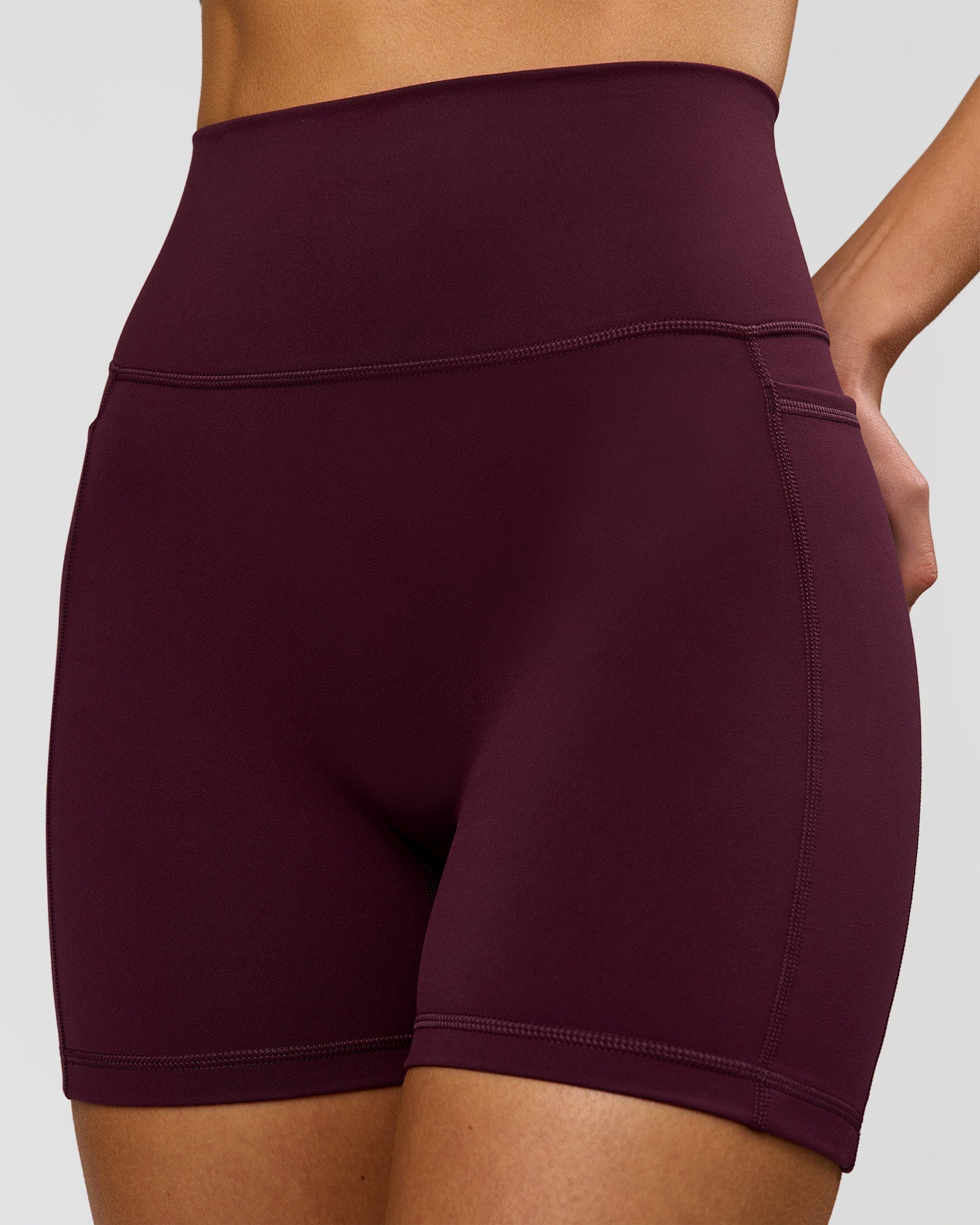 Woman wearing Fusion V-Contour Ultra High-Rise 4" Short Pockets - Cherry Lacquer | Model:Taneisha | Size:XS