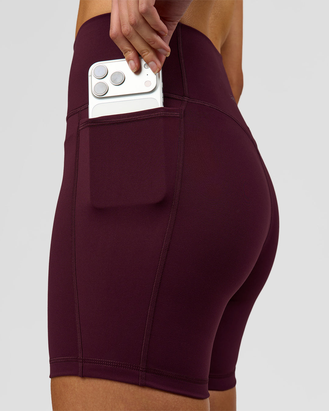 Woman wearing Fusion V-Contour Ultra High-Rise 6" Short Pockets - Cherry Lacquer | Model:Taneisha | Size:XS - view 4