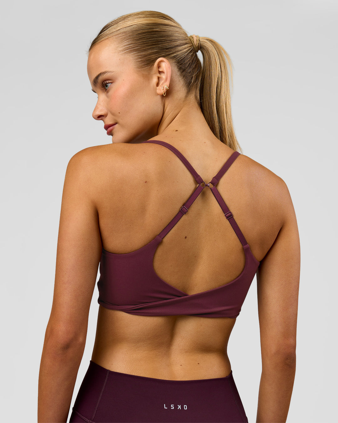 Woman wearing Twist Sports Bra - Cherry Lacquer | Model:Taneisha | Size:XS - view 1