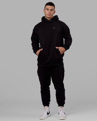 Man wearing Unisex Capsule Track Pant - Black | Thumbnail Index: 2