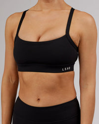 Woman wearing Momentum Sports Bra - Black | Thumbnail Index: 9