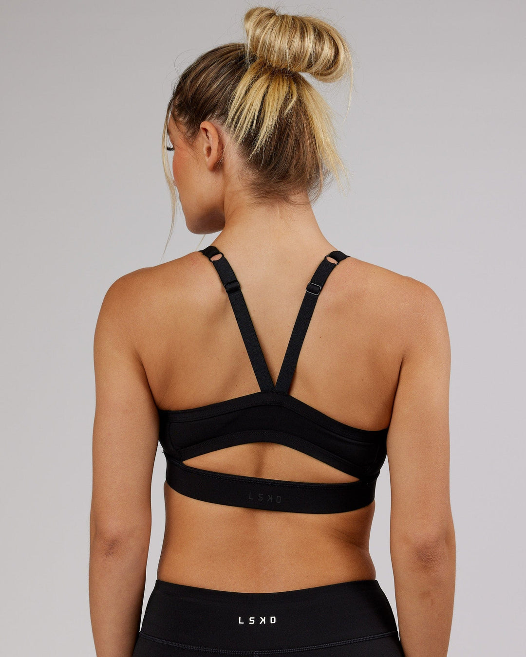 Woman wearing Momentum Sports Bra - Black - view 2