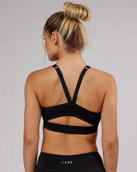 Woman wearing Momentum Sports Bra - Black | Thumbnail Index: 1